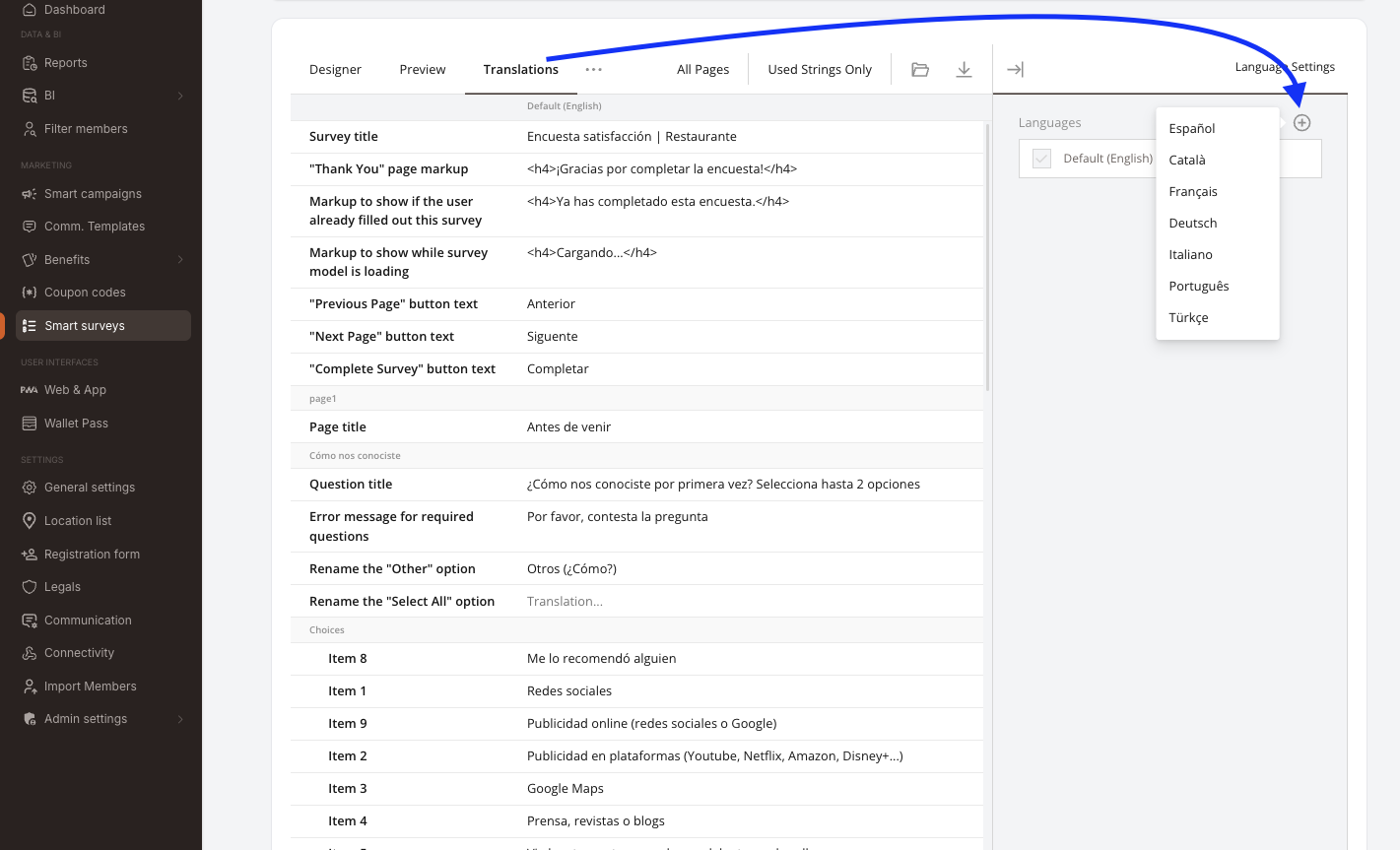 Der Translations-Tab im Umfrage-Builder. Tab-Leiste: Designer / Preview / Translations, mit den Filtern All Pages und Used Strings Only sowie Import- / Export-Icons. Das Raster listet links jeden übersetzbaren Text (Survey title, Markup der "Thank You"-Seite, Text der Buttons Previous / Next / Complete, Seitentitel, Fragetitel, Fehlermeldungen, Antwortoptionen), die Spalte Default (English) ist auf Spanisch ausgefüllt. Rechts listet das Panel Language Settings die bereits hinzugefügten Sprachen, mit einem +-Button, der ein Dropdown der verfügbaren Sprachen öffnet: Español, Català, Français, Deutsch, Italiano, Português, Türkçe.